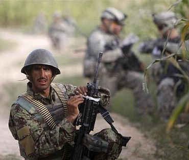 An Afghan army soldier takes up position during a joint patrol with US army soldiers from Delta Company, a part of Task Force 1-66, near the village of Mohammad D'Jakub, Arghandab River valley, Kandahar province
