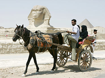 A horse drawn carriage passes in front of the Sphinx at The Pyramids of Giza in Egypt