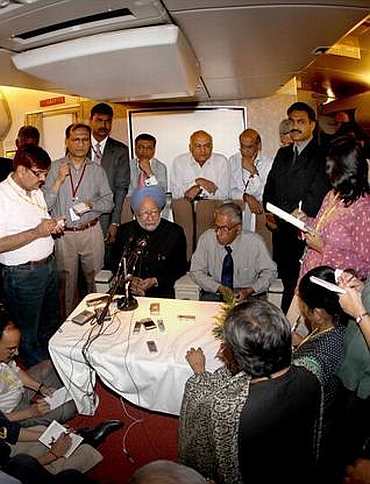 Dr Singh interacts with journalists on board his special aircraft in 2009 along with his then NSA MK Narayanan