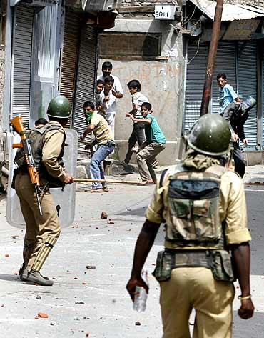 Kashmiri protesters throw stones towards Indian police during a protest in Srinagar