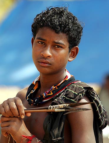 An Indian tribal teenager holds a bow and arrows at a relief camp in Dharbaguda in Chhattisgarh