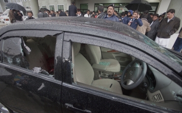 Police and members of the media stand near the bullet-riddled car of slain Pakistan's Minister for Minorities Shahbaz Bhatti outside the emergency ward of a hospital in Islamabad