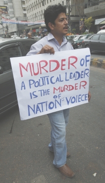 A supporter of the South Asia Forum for Human Rights holds a placard during a protest in Karachi