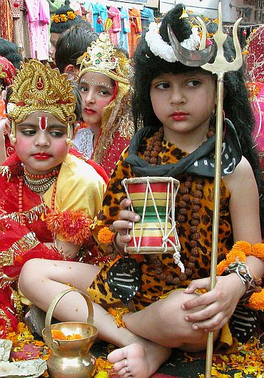 A boy dressed as God Shiva sits during a religious procession in Jammu.