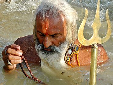 A sadhu offers prayer to Lord Shiva in the river Ganga in Allahabad.