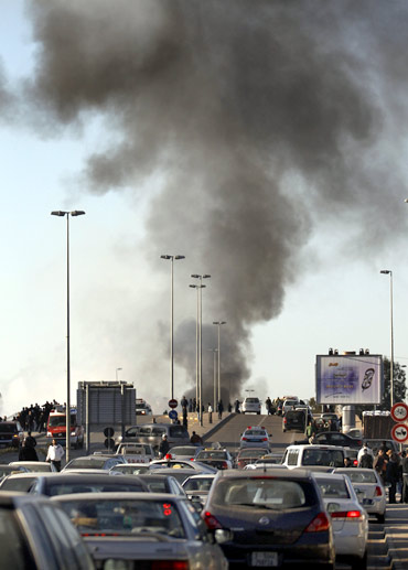 Smoke rises from a burning fuel truck as traffic is rerouted in Tripoli