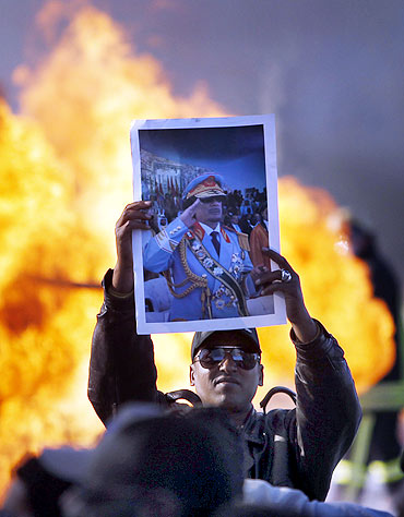 A man holds up a poster of Libya's leader Muammar Gaddafi