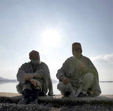 Two men chat on the banks of Dal Lake in Srinagar