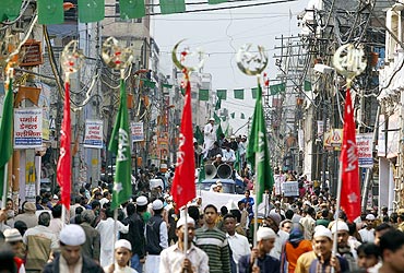 Muslims hold religious flags as they take part in a procession to mark Eid-e-Milad-ul-Nabi in the old quarters of Delhi