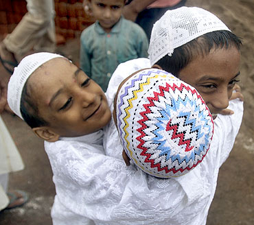 Muslim boys greet one another after offering Eid al-Fitr prayers outside a mosque at Noida