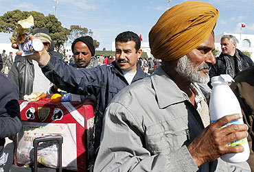 Indian migrants fleeing unrest in Libya receive refreshments at the Tunisian border crossing of Ras Jdir