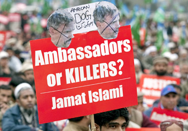 A supporter of Jamaat-e-Islami holds a placard during a protest rally against Davis