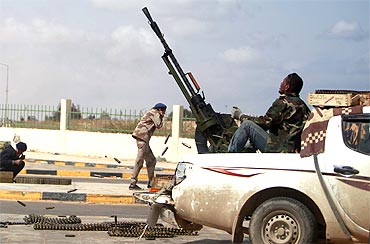 An anti-Gaddafi rebel fires an anti-aircraft gun