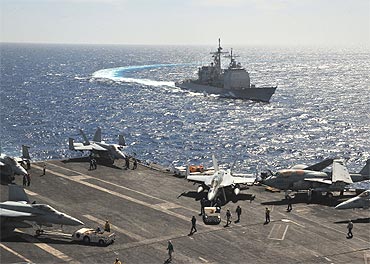 The missile cruiser USS Leyte Gulf pulls alongside the aircraft carrier USS Enterprise while conducting flight operations in the Red Sea