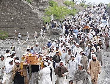 Pakistani tribesmen carry coffins during the funeral procession of victims of a suicide blast