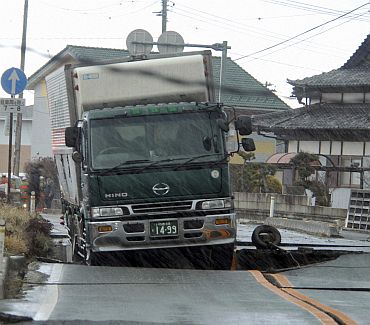 A truck is stuck on a road crack after a powerful earthquake in Iwaki, Fukushima Prefecture