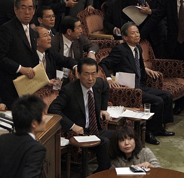 Japan's Prime Minister Naoto Kan (C) reacts he feels the quake in the upper house of parliament