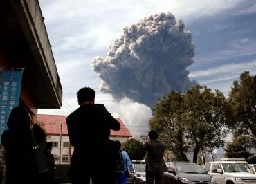 Smoke rises from Shinmoedake peak, a mountain in the Kirishima volcanic range between Kagoshima and Miyazaki prefectures, as people watch from Takaharu town, southern Japan