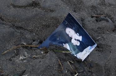 A family photograph is half buried in the mud in Rikuzentakata after it was a destroyed by an 8.9 magnitude earthquake and tsunami