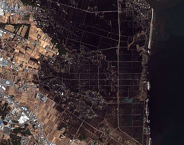This is a handout satellite image showing damage after an earthquake and tsunami in Minamisoma