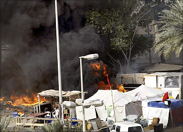 Tents are seen engulfed with fire as Gulf Cooperation Council forces move into Pearl Square to evacuate anti-government protesters in Manama