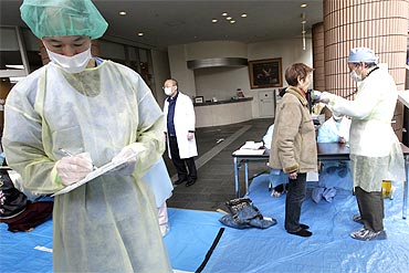 Medical staff screen people at a public welfare centre in Niigata, northern Japan