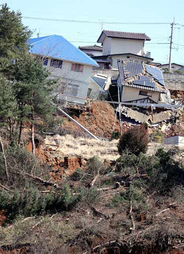 Houses are left damaged by landslides triggered by a quake off the coast of north-eastern Japan