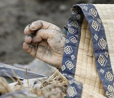 The body of a victim is seen covered at a village destroyed by the earthquake and tsunami in Rikuzentakata in Iwate prefecture