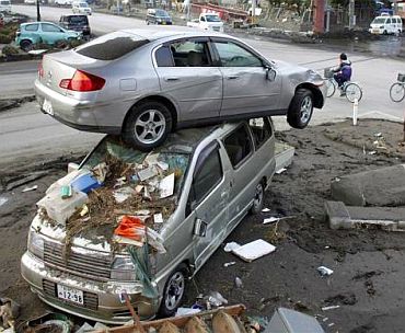 A car sits atop another in an area affected by an earthquake and tsunami in Miyako, Iwate prefecture