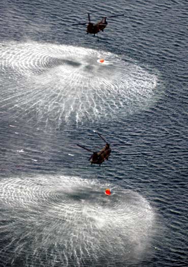 Japan Air Self-Defense Force CH-47 Chinook helicopters collect water from the ocean to drop on the reactors at the Fukushima Daiichi nuclear plant in Fukushima