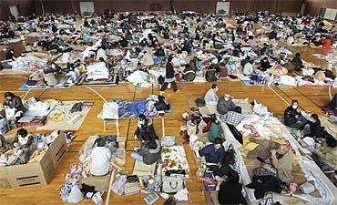 Evacuees, who fled from the vicinity of Fukushima nuclear power plant, sleep at an evacuation center