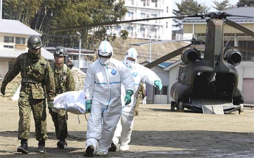 Japan Self-Defense Forces officers carry a victim who is suspected of being exposed to radiation