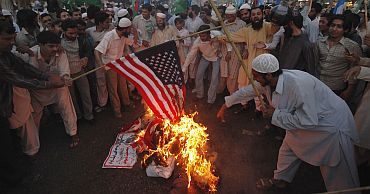 Supporters of Pakistan's religious and political party Jamaat-e-Islami set ablaze a US flag as they take part in a protest rally against the release Raymond Davis in Karachi