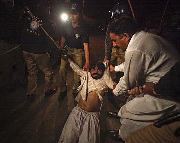 Police arrest an activist of a Pakistani political party during a protest rally in Lahore