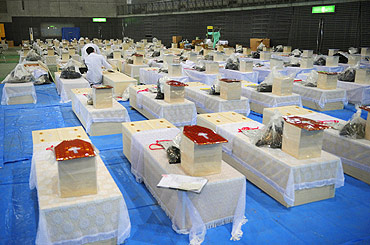 Caskets containing the bodies of earthquake and tsunami victims are arranged in a hall in Rifu-cho, Miyagi prefecture