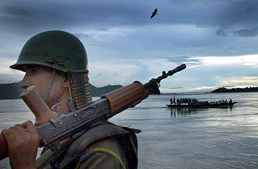 A soldier stands guard on the banks of the river Brahmaputra on the outskirts of Guwahati