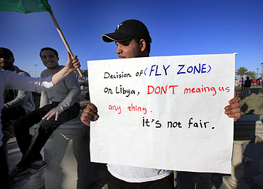 A Gaddafi supporter holds a placard during a protest in Tripoli