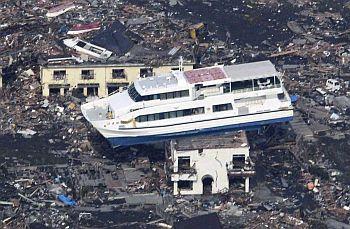 A ferry is perched on top of a house in the aftermath of an earthquake and tsunami in Otsuchi, Iwate prefecture