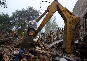 Rescue workers search for survivors under the rubble of a collapsed building in New Delhi, which left over 50 people dead in November