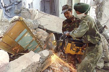Indian soldiers use a concrete cutter at a collapsed apartment building in the western Indian town of Bhuj, where over 30,000 people died in the 2001 quake