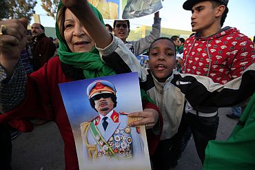 Supporters of Libya's leader Muammar Gaddafi shout slogans as they arrive at Bab Al- Aziziyah