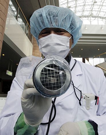 Medical staff use a Geiger counter to screen a photographer for possible radiation exposure at a public welfare centre in Niigata, northern Japan