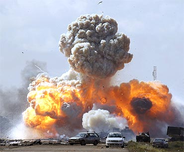 Vehicles belonging to forces loyal to Libyan leader Muammar Gaddafi explode after an air strike by coalition forces