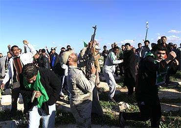 A Libyan soldier fires in the air during the funeral of persons who were killed by US air strikes