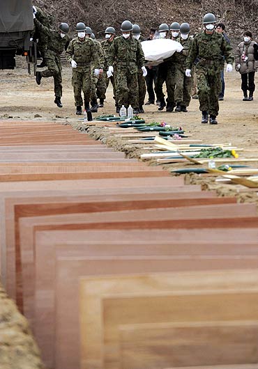 Japan Ground Self Defense Force members prepare to bury victims of the March 11 earthquake and tsunami at a temporary mass grave in Higashi Matsushima, northern Japan