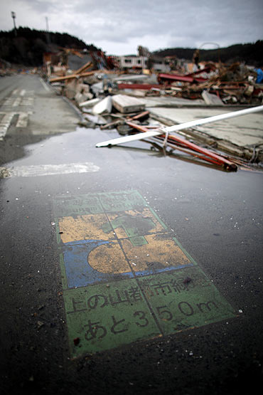 A tsunami refuge warning painted on the road is seen in an area destroyed by the earthquake