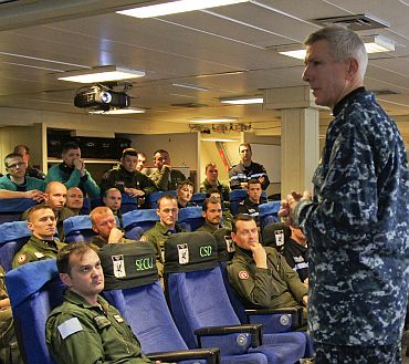 Adm Samuel J Locklear, III, commander, Joint Task Force Odyssey Dawn, speaks with an aircrew team from the French Navy aircraft carrier Charles de Gaulle