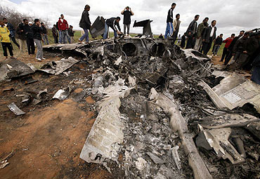 People look at a US Air Force F-15E fighter jet after it crashed near the eastern city of Benghazi
