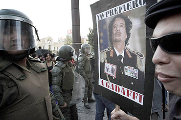 A demonstrator holds a poster with the picture of Libya's leader Muammar Gaddafi