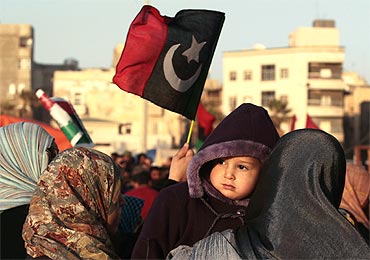 A protester holds her baby during an anti-Gaddafi demonstration in Benghazi